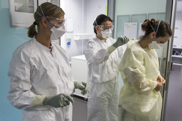 epa04459144 Doctors and nurses take part in training in treating infectious deseases in an isolation room during a presentation on diagnosing and treating patients with Ebola virus symptoms, in the In ...