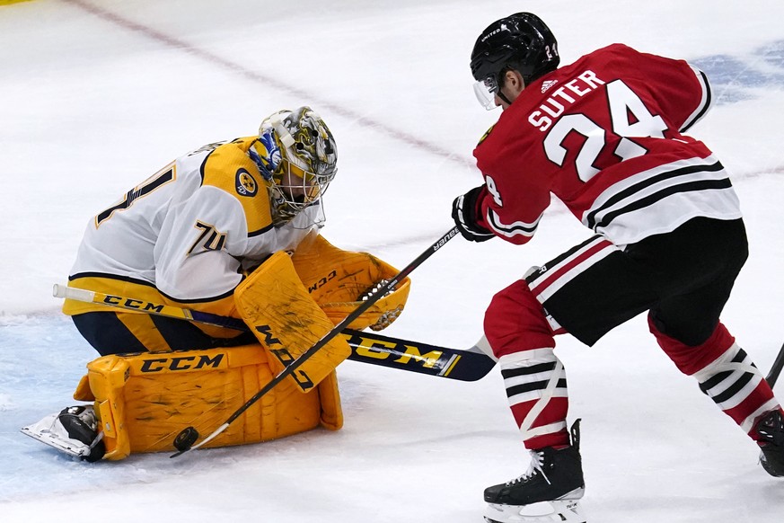 Nashville Predators goaltender Juuse Saros, left, makes a save on a shot by Chicago Blackhawks center Pius Suter during the third period of an NHL hockey game in Chicago, Saturday, March 27, 2021. (AP ...