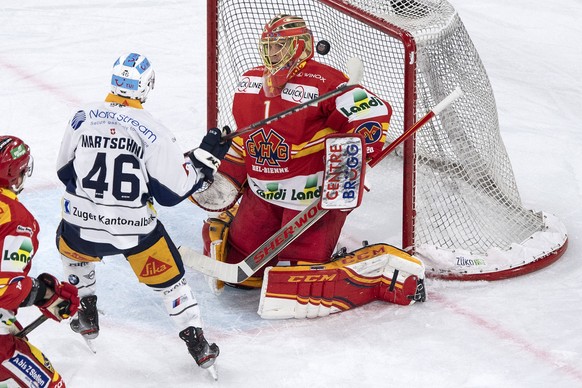 Biels Goalie Jonas Hiller, links, ist gegen Zugs Lino Martschini zum 2:3 geschlagen, im Eishockey Meisterschaftsspiel der National League zwischen dem EHC Biel und dem EV Zug, am Freitag, 10. Januar 2 ...