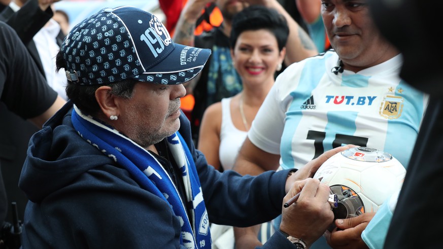 epa06893530 Former Argentinian soccer player Diego Maradona signs a ball before the soccer match between FC Dinamo Brest and FC Shakhtyor at the central stadium in Brest, Belarus, 16 July 2018. Marado ...