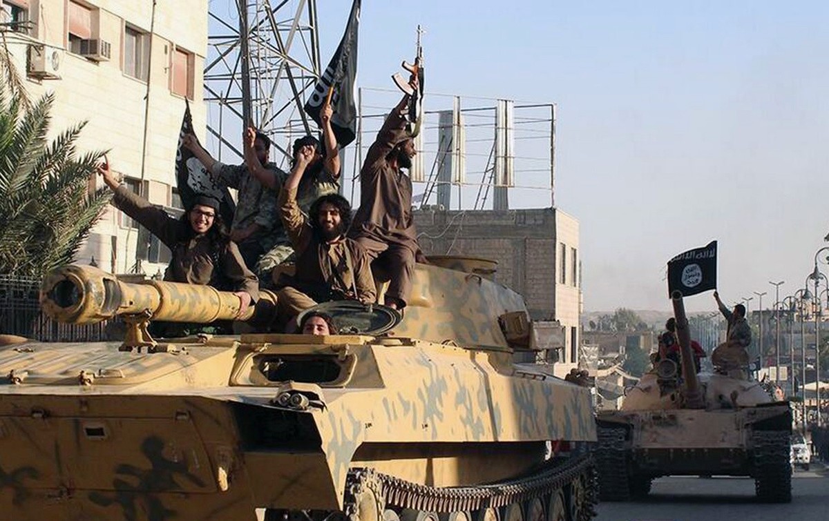 FILE- This undated image posted by the Raqqa Media Center, a Syrian opposition group, on Monday, June 30, 2014, which has been verified and is consistent with other AP reporting, shows fighters from t ...