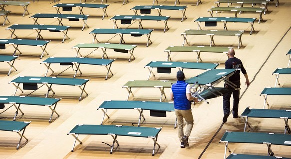 Tyler Peoples, left, and Jason Horn, of the Springs Rescue Mission, set up cots in the City Auditorium, Wednesday, April 1, 2020, as the Colorado Springs, Colo., rescue mission sets up an isolation sh ...