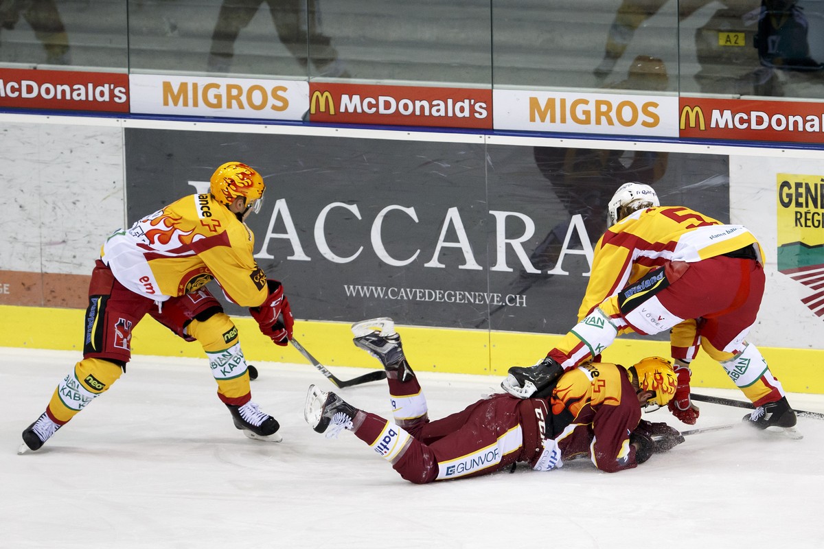 Geneve-Servette's center Tanner Richard, center, falls between Tigers' forward Antti Erkinjuntti, of Finland, left, and Tigers' defender Yves Mueller, right, during a National League re ...