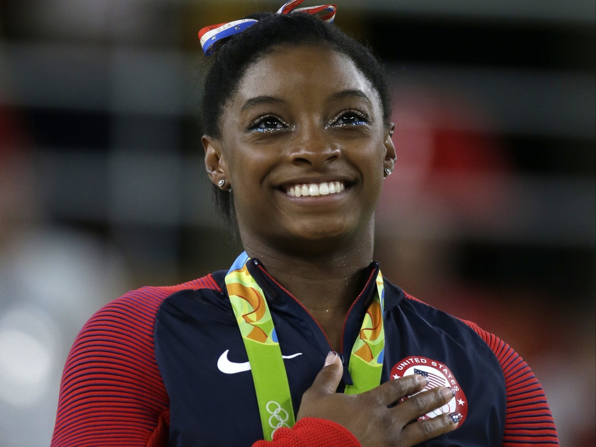FILE - In this Aug. 16, 2016, file photo, United States' Simone Biles stands during the national anthem after winning the gold medal in the women's floor exercise at the 2016 Summer Olympics ...