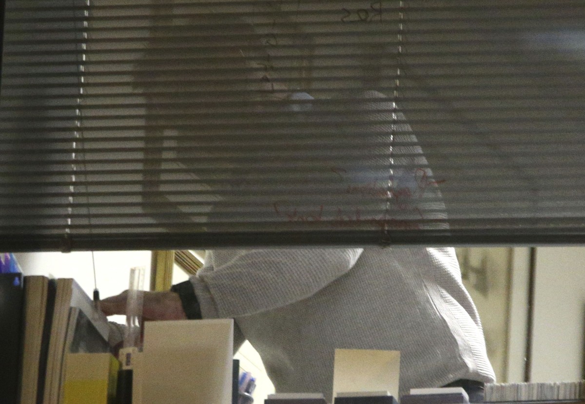 The scene at a window as Information Commissioner's Office enforcement officers work inside the offices of Cambridge Analytica in central London after a High Court judge granted a search warrant, ...