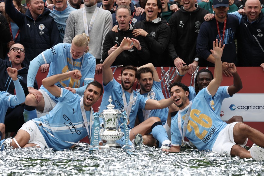 Manchester City players pose with the winner's trophy after the English FA Cup final soccer match between Chelsea and Manchester City in London, Saturday, May 16, 2026. (AP Photo/Richard Pelham)
 ...