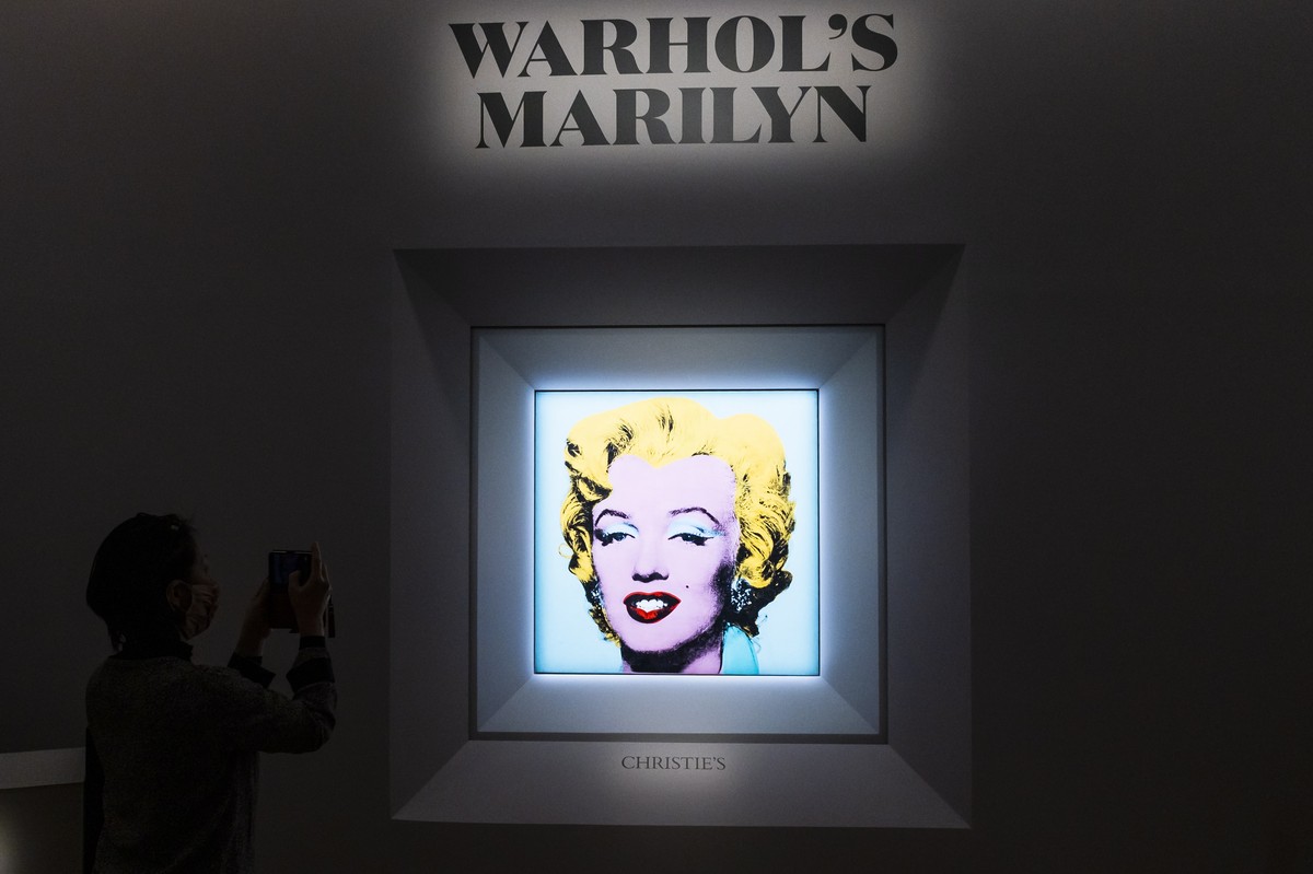 epa09840752 People look at the 1964 painting 'Shot Sage Blue Marilyn' by Andy Warhol during a press conference announcing the upcoming auction of the painting at Christie's in New York, ...