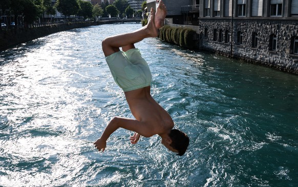 Ein Mann springt in die Aare, am Donnerstag, 16. Juni 2022, in Thun. In den naechsten Tagen werden Temparaturen ueber dreissig Grad erwartet. (KEYSTONE/Peter Schneider)