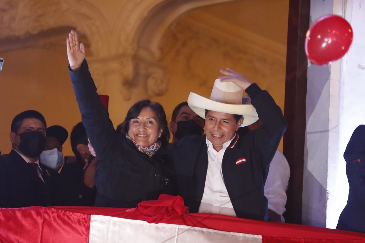 epa09353988 The leftist Pedro Castillo (R), accompanied by his formula to the Vice Presidency Dina Boluarte, greets supporters from a balcony after being proclaimed president-elect of the country, in  ...
