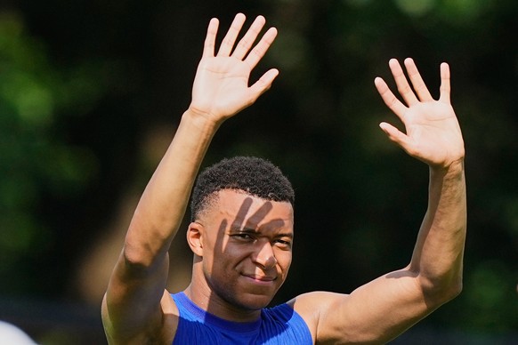 France's Kylian Mbappe reacts to fans in the hot sun during a training session during the FIFA World Cup soccer tournament, at the France base camp in Waltham, Mass., near Boston, Friday, June 12 ...