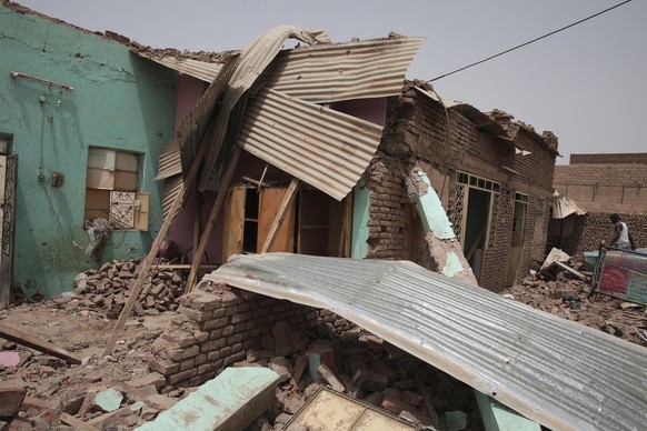 A man walks by a house hit in recent fighting in Khartoum, Sudan, Tuesday, April 25, 2023. Sudan&#039;s warring generals have pledged to observe a new three-day truce that was brokered by the United S ...