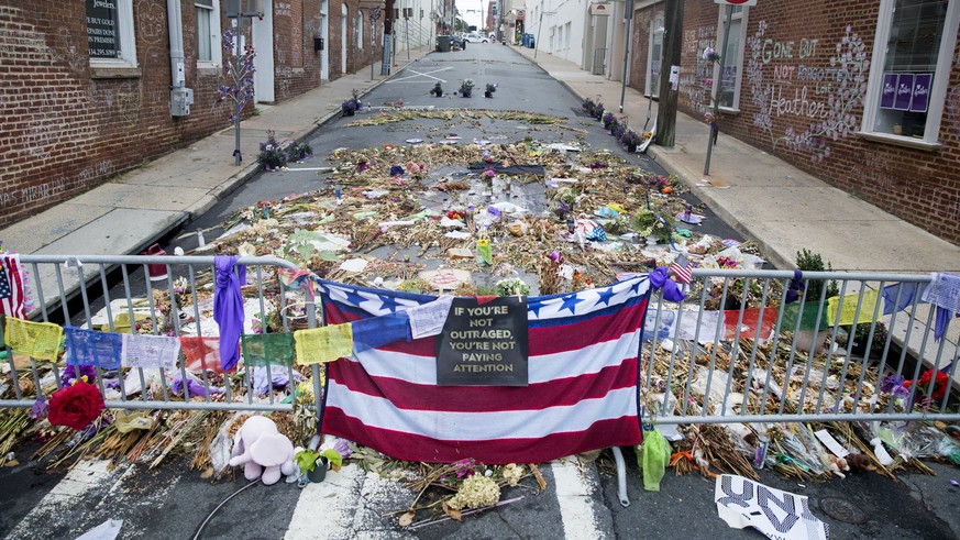 epa06159869 Flowers, candles and other items are placed in memory of Heather Heyer and for those affected by the violence at the site where a vehicle smashed into counter-protesters in Charlottesville ...