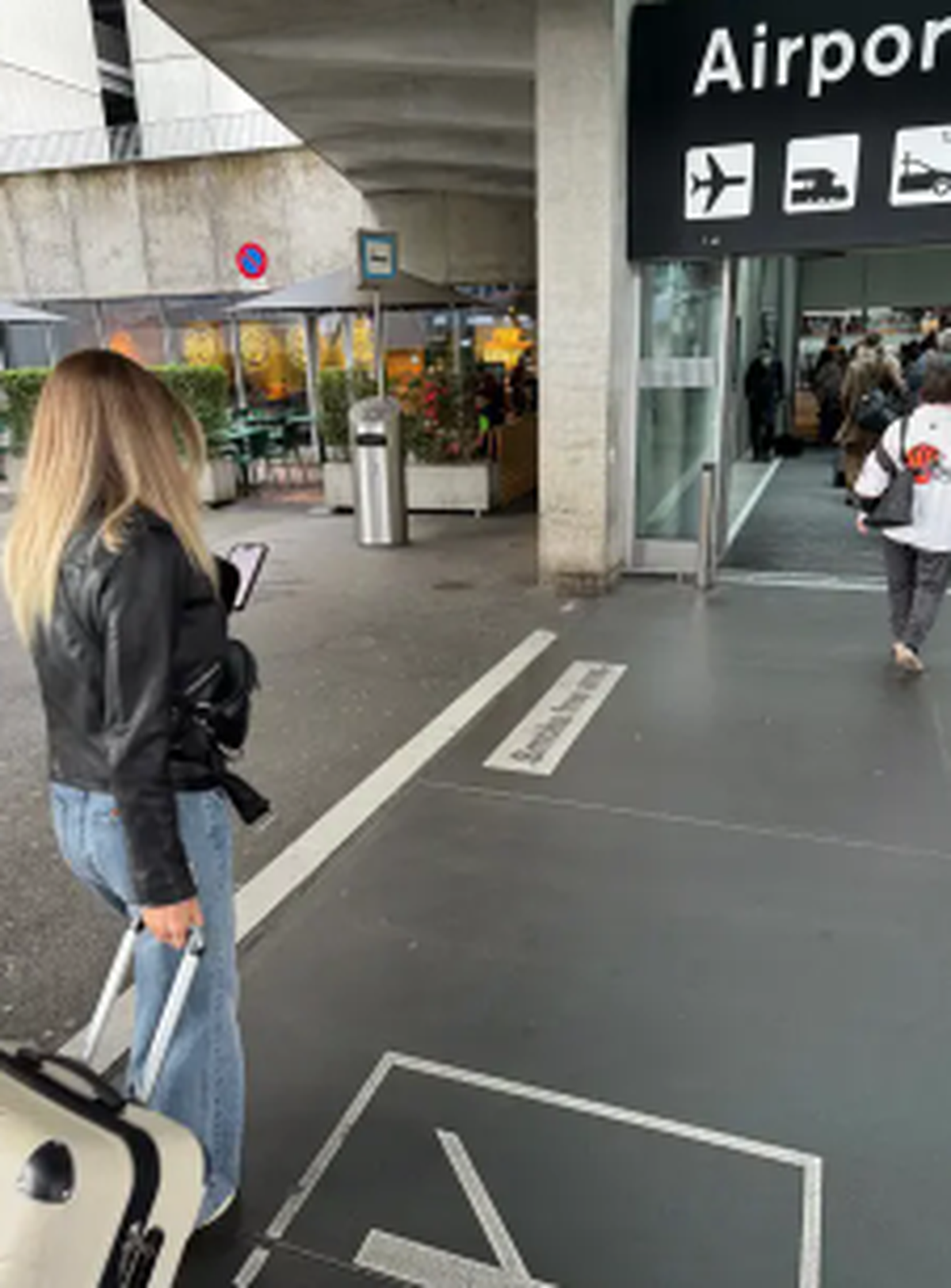 Der Flughafeneingang beim Bus- und Tramhof: Links ist das Rauchen erlaubt, rechts nicht. Am Boden kennzeichnet ein Streifen die imaginäre Grenze in der Luft.