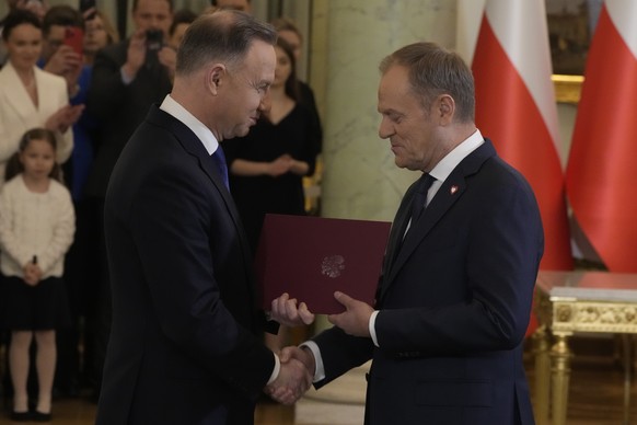 Poland&#039;s new Prime Minister Donald Tusk, right, shakes hands with Poland&#039;s President Andrzej Duda during the swearing-in ceremony at the presidential palace in Warsaw, Poland, Wednesday, Dec ...