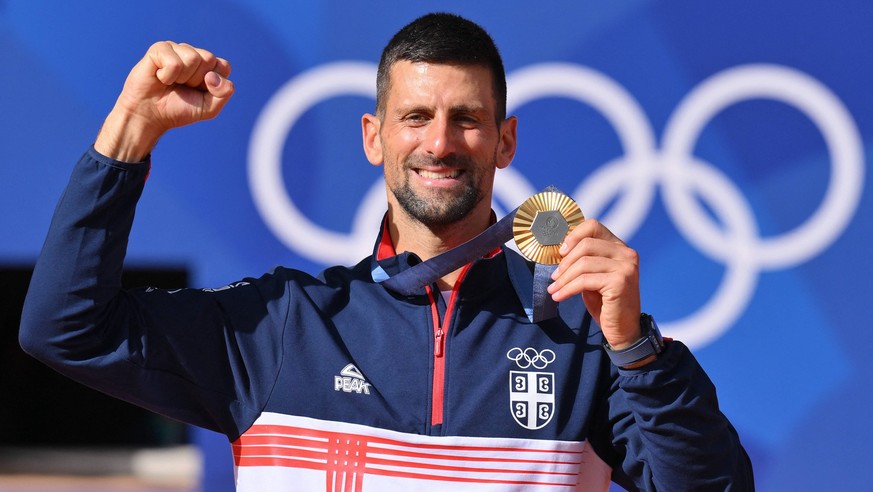 Paris 2024 - Tennis - Novak Djokovic Wins Gold Gold medalist Novak Djokovic of Team Serbia celebrates on the podium during the Tennis Men s Singles medal ceremony after the Tennis Men s Singles Gold m ...