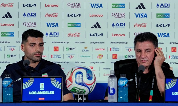 Iran head coach Amir Ghalehnoy, right, and player Mehdi Taremi listens to a question during a press conference ahead of their FIFA World Cup match against New Zealand in Inglewood, Calif., near Los An ...