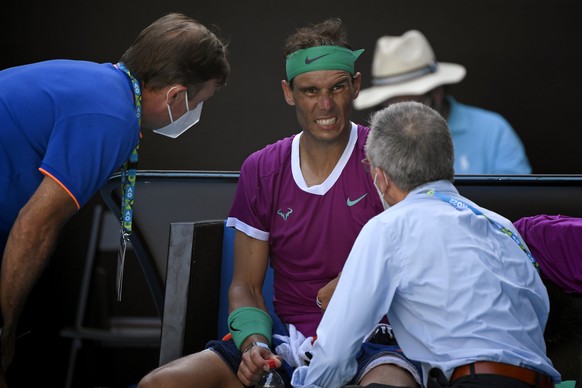 Rafael Nadal of Spain talks to medical staff during a break in his quarterfinal match against Denis Shapovalov of Canada at the Australian Open tennis championships in Melbourne, Australia, Tuesday, Jan. 25, 2022. (AP Photo/Andy Brownbill)
Rafael Nadal