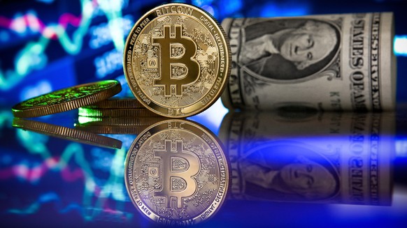 epa08957195 (FILE) - A bitcoin in front of a monitor showing a stock barometer in Duesseldorf, Germany, 20 January 2021 (reissued 22 January 2021). Media reports 22 January 2021 state cryptocurrency B ...