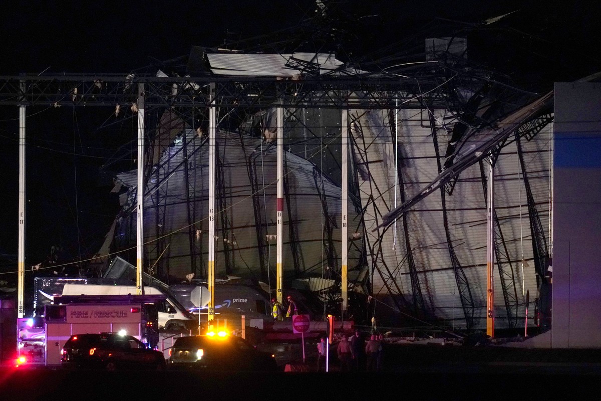 First responders work outside an Amazon fulfillment center after it was heavily damaged when a strong thunderstorm moved through the area Friday, Dec. 10, 2021, in Edwardsville, Ill. (AP Photo/Jeff Ro ...