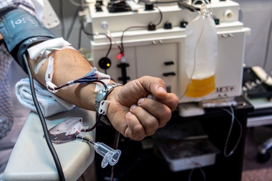 epa08715073 Enrique, a patient who has recovered from Covid-19, donates blood - from which the plasma is extracted (R) - at the Son Llatzer hospital in Palma de Mallorca, Balearic Islands, Spain, 02 O ...