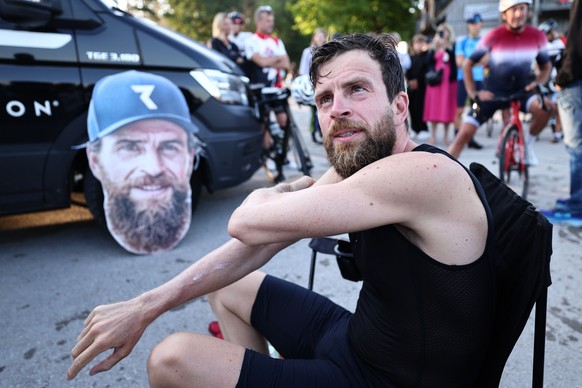 epa11586077 Extreme athlete Jonas Deichmann puts on sunscreen while talking to a journalist in the break after swimming on the last day of his challenge to complete 120 ironman distance triathlons in  ...