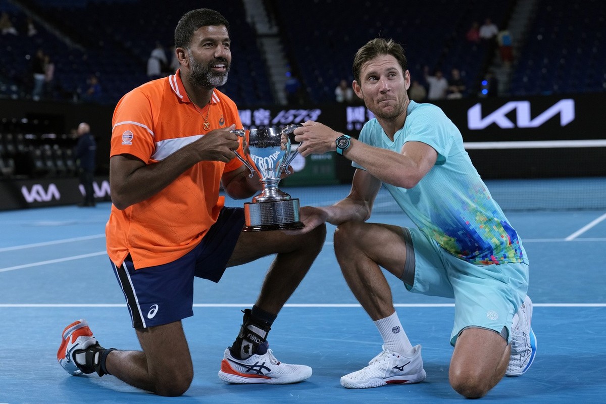 Rohan Bopanna, left, of India and Matthew Ebden of Australia pose with their trophy after defeating Simone Bolelli and Andrea Vavassori of Italy in the men's doubles final at the Australian Open  ...