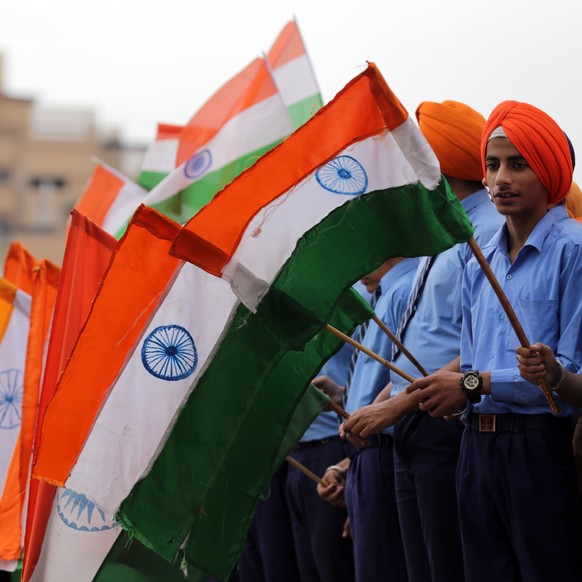 epa07500699 Students hold Indian flags as they take part in an event held to pay tribute to the martyrs of the Jallianwala Bagh Massacre on the eve of massacre's 100th anniversary, near the Jalli ...