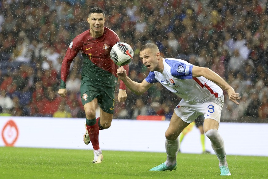 Slovakia&#039;s Denis Vavro heads the ball in front of Portugal&#039;s Cristiano Ronaldo during the Euro 2024 group J qualifying soccer match between Portugal and Slovakia at the Dragao stadium in Por ...