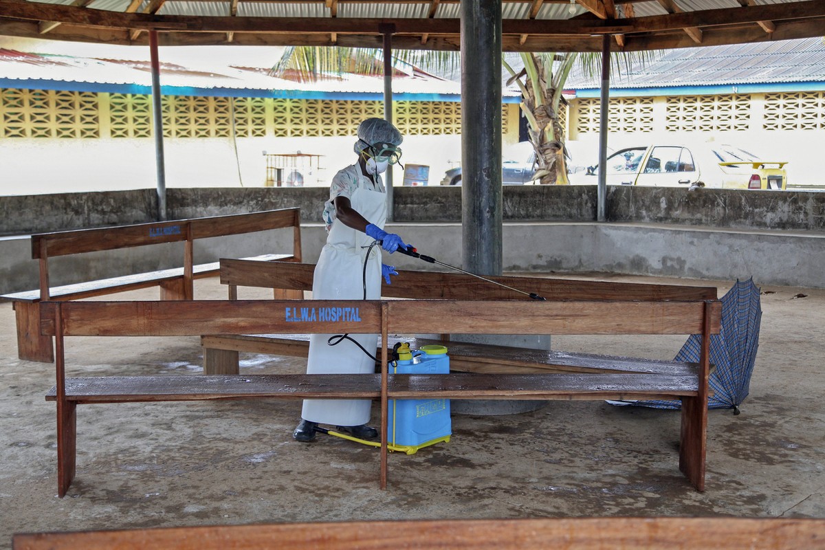 epaselect epa04334022 A nurse from Liberia sprays preventives to disinfect the waiting area for visitors at the ELWA Hospital where a US doctor Kent Bradley is being quarantined in the hospitals isola ...