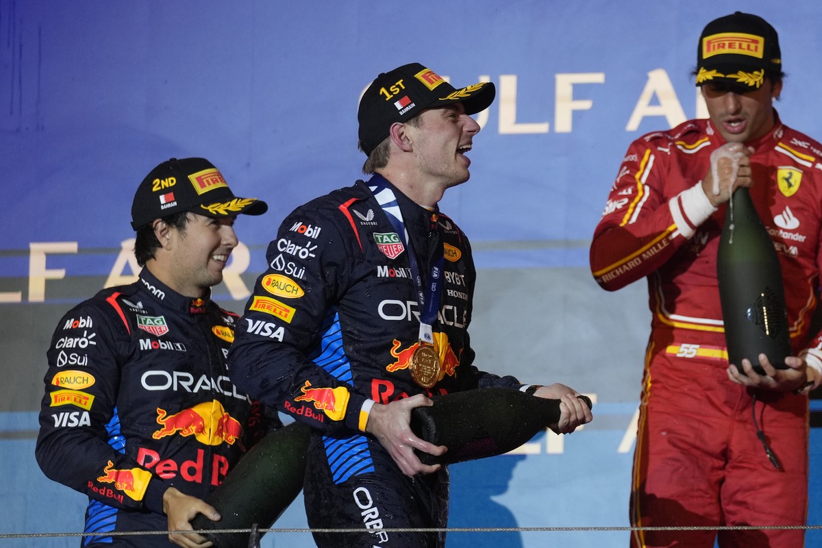 First place, Red Bull driver Max Verstappen of the Netherlands, center, celebrates on the podium with second place, Red Bull driver Sergio Perez of Mexico, left, and third place, Ferrari driver Carlos ...