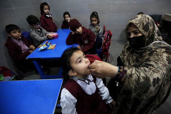 epa11198604 A health worker administers polio vaccine drops to a child during a door-to-door vaccination campaign, in Peshawar, Pakistan, 04 March 2024. A five-day nationwide polio vaccination campaig ...