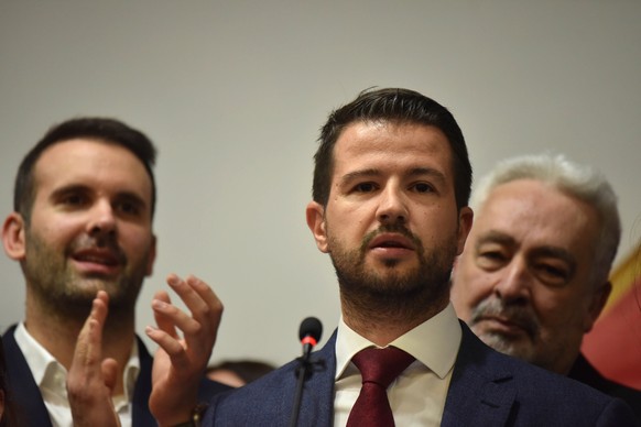 epa10556379 Jakov Milatovic (center), the presidential candidate of Montenegro, addresses the media after the first results of the second round of the presidential election in Podgorica, Montenegro, Apr. 02