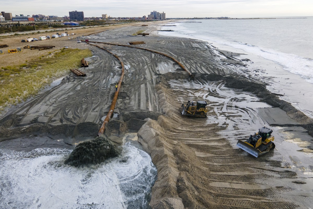 FILE - Contractors for the U.S. Army Corps of Engineers pump sand from the ocean floor onto the beach in the Rockaway Peninsula in New York City on, Oct. 18, 2022. They are crafting a 250-foot wide sa ...
