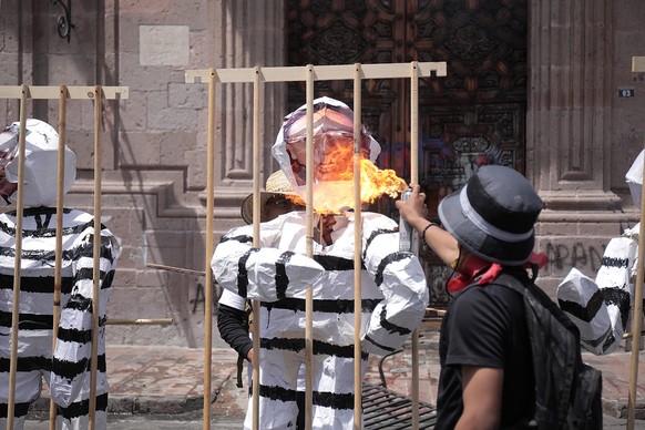 epa09872801 Residents of Arantepacua set effigies on fire as they protest outside the facilities of the Government Palace of Morelia, in Michoacan state, Mexico, 05 April 2022. Purepecha indigenous pe ...