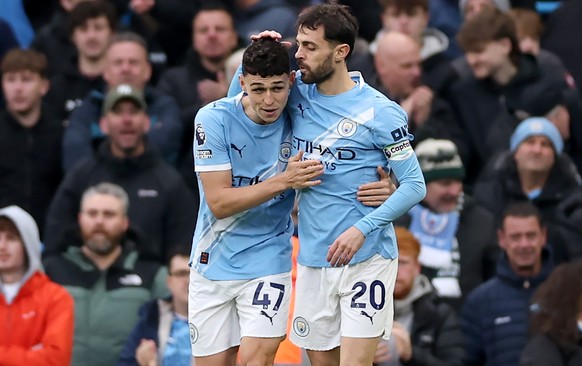 epa12557272 Phil Foden (L) of Manchester City celebrates with teammates Bernardo Silva after scoring the opening goal during the English Premier League match between Manchester City and Leeds United i ...