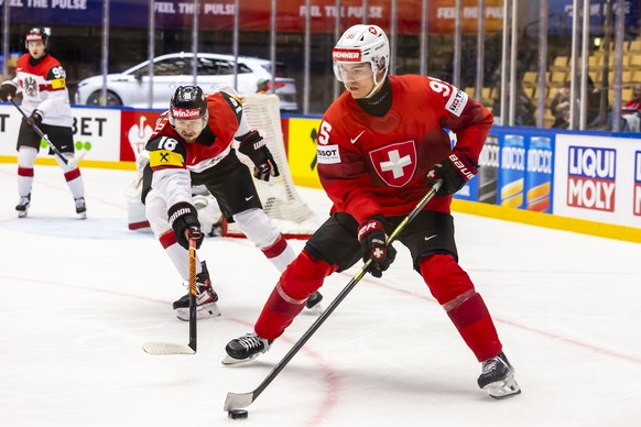 epa12126199 Austria's defender Paul Stapelfeldt, left, vies for the puck with Switzerland's forward Tyler Moy, right, during the 2025 IIHF Ice Hockey World Championship quarter final match b ...