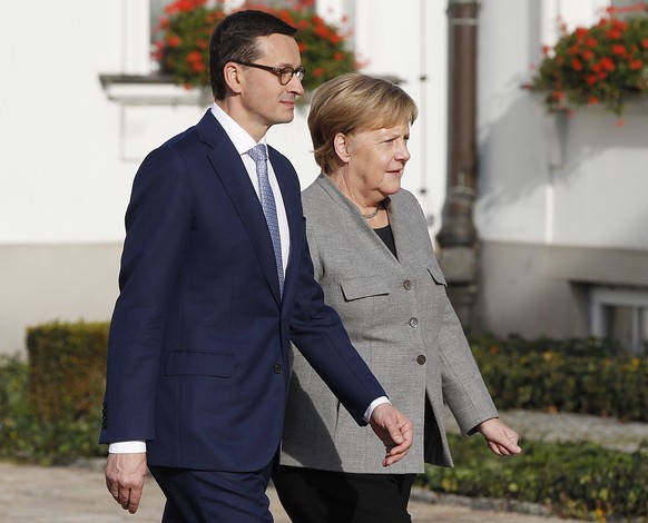 Polish Prime Minister Mateusz Morawiecki, left, welcomes German Chancellor Angela Merkel, right, ahead of intergovernmental consultations in Warsaw, Poland, Friday Nov. 2, 2018. Merkel is visiting War ...