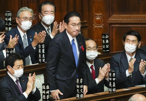 epa09504866 Fumio Kishida (C) is celebrated by his fellow lawmakers after being elected as new Prime Minister, during the general assembly of an extraordinary parliamentary session in Tokyo, Japan, 04 ...