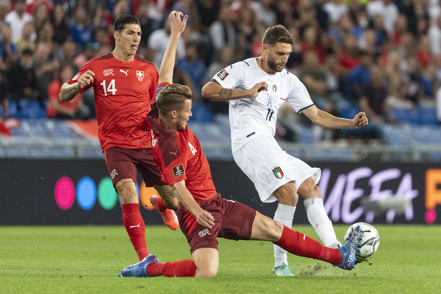 Switzerland&#039;s Steven Zuber and Nico Elvedi, from left, fight for the ball against Italy&#039;s Domenico Berardi, during the 2022 FIFA World Cup European Qualifying Group C soccer match between Sw ...