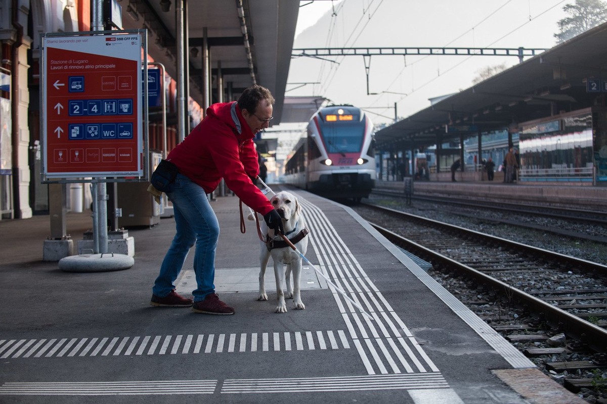 Christian Baroni laesst sich von einem zukuenftigen Blindenhund durch den SBB-Bahnhof Lugano fueheren, am Montag, 12. Dezember 2016. Das von Christian Baroni gefuehrte Zentrum "Chienguide" i ...