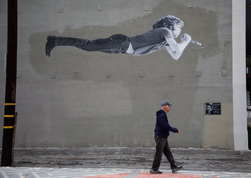 epa07211345 A person passes a photomural of the late musician Jim Morrison of The Doors classic rock band in Long Beach, California USA, 05 December 2018. Jim Morrison would have turned 75 on 08 Decem ...