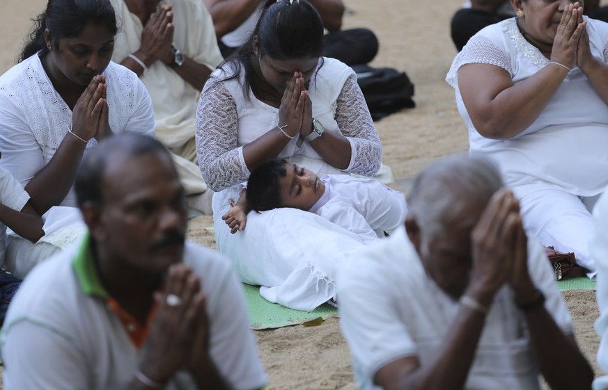 Sri Lankan Buddhists pray along with monks during a ceremony to invoke blessings on the dead and wounded from Sunday&#039;s bombings at the Kelaniya temple in Colombo, Sri Lanka, Wednesday, April 24,  ...