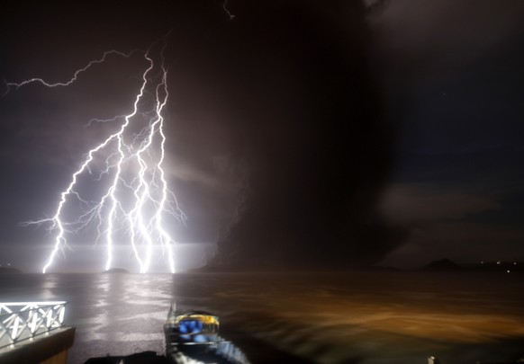 epa08122218 A view of a lightning strike over Taal Volcano during an eruption, in Talisay, Batangas, Philippines, 12 January 2020. Thousands of people have been ordered to evacuate as the authorities  ...