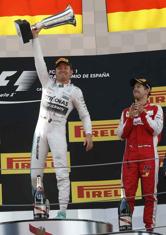 Winner Mercedes driver German's Nico Rosberg rises his trophy next to third place Ferrari driver Germany´s Sebastian Vettel, right, during the Spanish Formula One Grand Prix at the Barcelona Catalunya ...