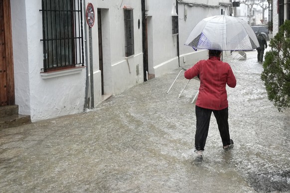 epaselect epa12704064 A woman walks through a street flooded by heavy rain in Grazalema, Cadiz, Andalusia, Spain, 04 February 2026. The Red Cross has mobilized volunteers from its Emergency Response T ...