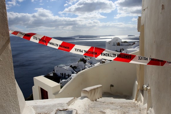 epa11876573 A cordon in a small street over the cliffs of the volcanic caldera of the almost evacuated village of Oia on Santorini island, Greece, 05 February 2025. Due to a wave of seismic activity n ...