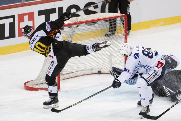 Berns Tristan Scherwey, links, schiesst ein Tor (5-4) gegen Ambris Michael Ngoy, und Ambris Torhueter Daniel Manzato im Swiss Ice Hockey Cup 1/4 Finalspiel zwischen dem SC Bern und den HC Ambri-Piotta ...