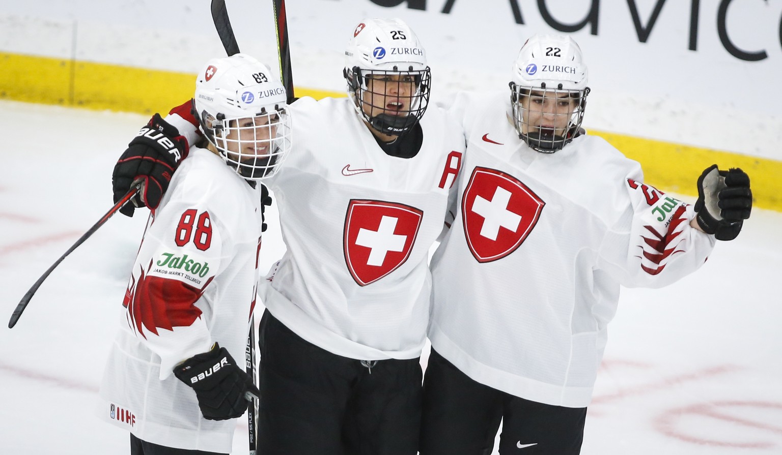 Switzerland&#039;s Alina Muller, center, celebrates her goal against Russia with Sinja Leemann, right, and Phoebe Staenz during the first period of an IIHF women&#039;s hockey championships game in Ca ...