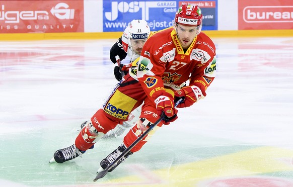 Luganos Mikkel Bodker, links, und Biels Yannick Rathgeb, rechts, kaempfen um den Puck, beim Eishockey Meisterschaftsspiel der National League zwischen dem EHC Biel und den HC Lugano, am Freitag, 18. D ...