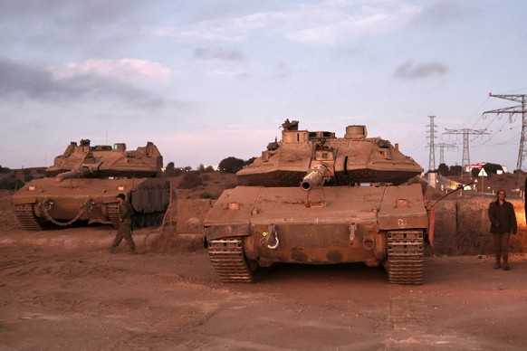 epa11614530 Israeli soldiers stand next to tanks waiting for transportation after a day of training in the center of the Israeli-annexed Golan Heights, 19 September 2024. The Israeli military said the ...